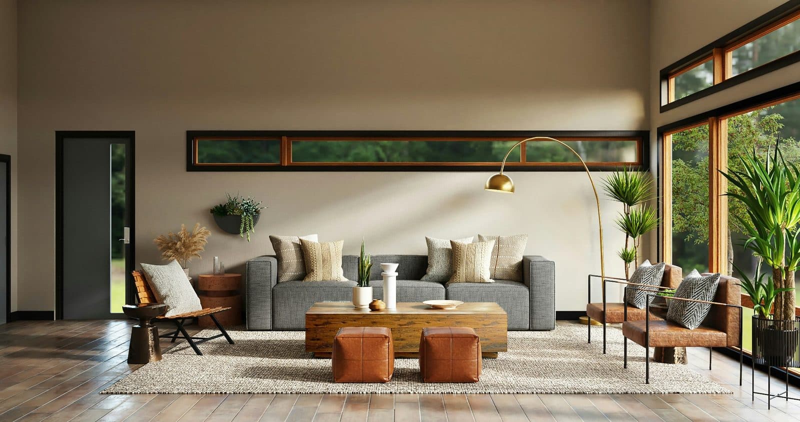 Le séjour sous la double hauteur : canapé gris, table basse en bois brut, un long bandeau vitré ouvert sur les arbres